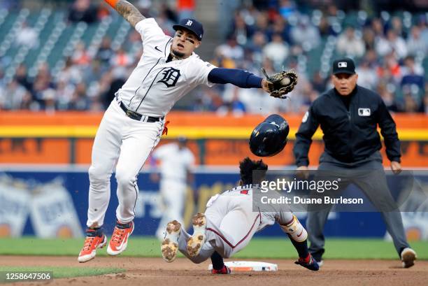 Ozzie Albies of the Atlanta Braves steals second base as shortstop Javier Baez of the Detroit Tigers reaches out for the throw on a pickoff during...