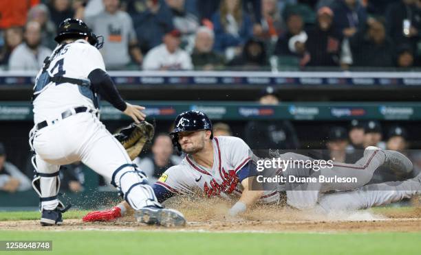 Sam Hilliard of the Atlanta Braves is out at the plate against catcher Jake Rogers of the Detroit Tigers trying to score on a fly ball off the bat of...