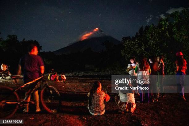 People watch as lava and ashes flow from the Mayon Volcano which remains under alert level 3, in Legazpi, Albay province, Philippines, on June 12,...