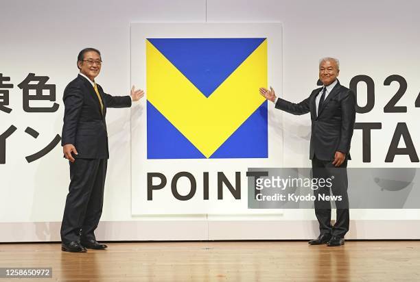 Sumitomo Mitsui Financial Group Inc. President Jun Ota and Culture Convenience Club Co. CEO Muneaki Masuda pose for a photo in front of the logo of...