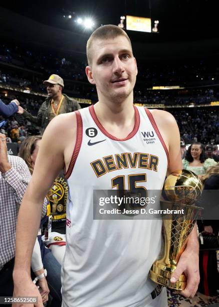 Nikola Jokic of the Denver Nuggets walks off the court with the Bill Russell MVP trophy after winning Game Five of the 2023 NBA Finals on June 12,...