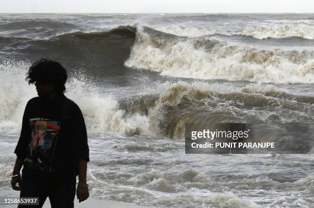 Man walks away from the seafront as high tidal waves hit the coast in Mumbai on June 13 as cyclone Biparjoy makes its way across the Arabian Sea...