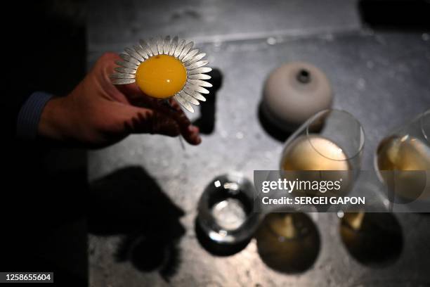 Man holds a creation called "Daisy", a mix of makrut lime, juniper and kombucha, as he visits the Alchemist restaurant in Copenhagen, Denmark, on May...