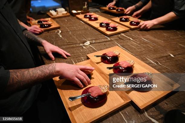 Chefs serve a creation called "Tongue kiss", rhubarb and elderflower gazpacho, at the Alchemist restaurant in Copenhagen, Denmark, on May 25, 2023....