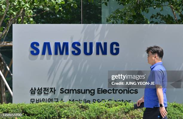 Man walks past the logo of Samsung Electronics at the company's headquarters in Suwon on June 13, 2023.