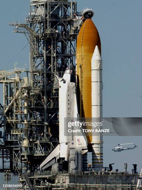 Helicopter flys by launch pad 39-B and the space shuttle Discovery at the Kennedy Space Center, FL 07 March 2001. Discovery and a crew of seven are...