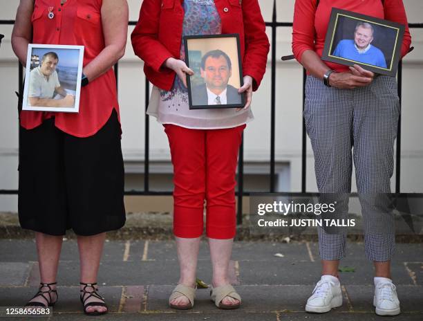 Members of the Covid-19 Bereaved Families for Justice hold photos of relatives who died during the pandemic, as they demonstrate outside the venue...