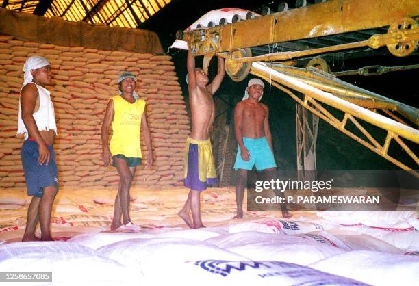 Workers at the sugar mill and refinery of the First Farmers Holding Corporation stacking up sugar bags for distribution in Bacolod, 10 October 2001....