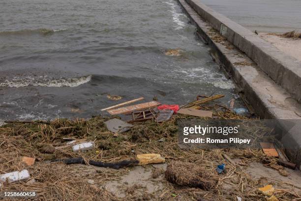 Polluted beach with objects some of which presumably were washed down the Dnipro River as the result of the Kakhovka dam destruction on June 13, 2023...