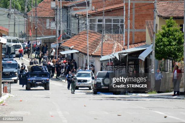 This photograph taken on June 13, 2023 shows Kosovo police officers patroling a street after clashes with ethnic Serbs as tensions erupted after...