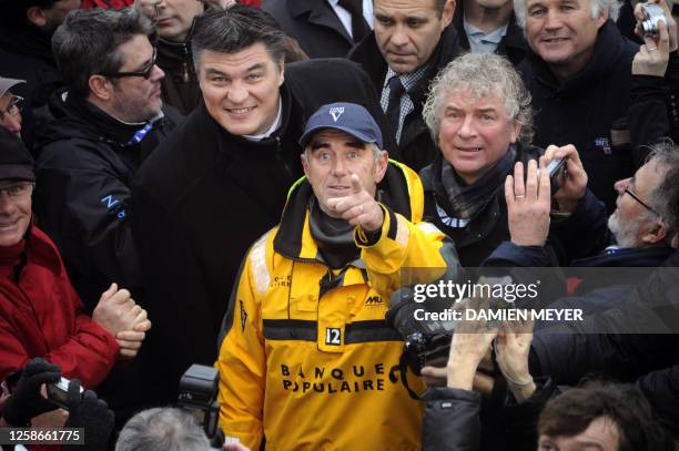 French skipper Loick Peyron , skipper of the Banque Populaire V, stands beside French Sports Minister David Douillet , surrounded by journalists and...
