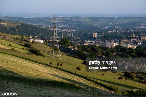 Elevated view looking over the town centre from and towards the surrounding countryside where red cattle are grazing on 9th June 2023 in Halifax,...