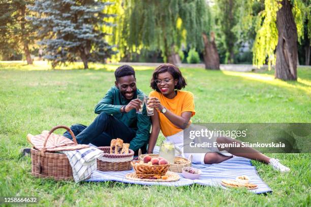 young black couple on picnic in the park. - woman eating toast photos et images de collection