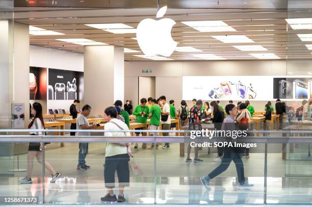 Customers are seen at the American multinational technology company Apple store and logo in Hong Kong.