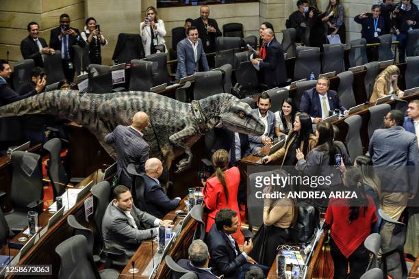 Person in a dinosaur costume makes an appearance at the Colombia Congress during a debate on climate change, in Bogota on June 13, 2023. The...