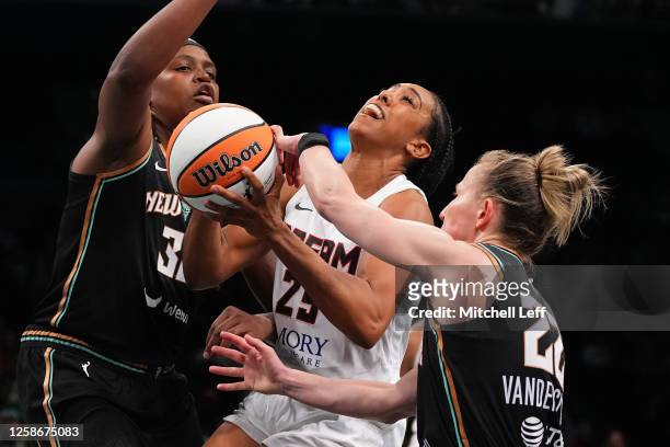 Monique Billings of the Atlanta Dream drives to the basket against Jonquel Jones and Courtney Vandersloot of the New York Liberty in the second half...