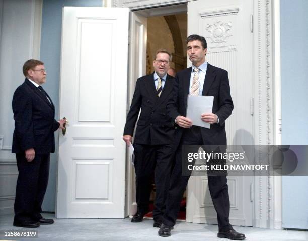 Denmark's Prime Minister Anders Fogh Rasmussen and Foreign Minister Per Stig Moeller enter a room where they will address the media 07 February 2006,...