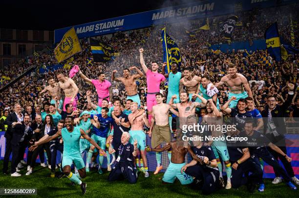 Players and staff of Hellas Verona FC celebrate the victory at the end of the Serie A relegation play-off football match between Spezia Calcio and...