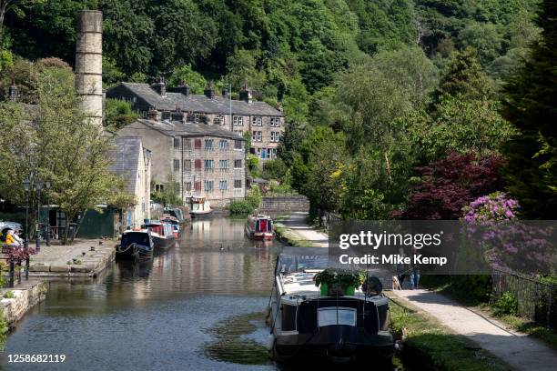 Scene of old industrial mill buildings along the Rochdale Canal on 7th June 2023 in Hebden Bridge, United Kingdom. In the 19th and 20th centuries the...