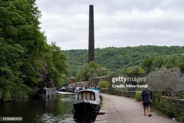 Scene of old industrial mill buildings along the Rochdale Canal on 7th June 2023 in Hebden Bridge, United Kingdom. In the 19th and 20th centuries the...