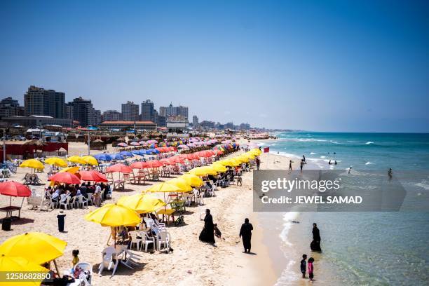 Women walk out of the Mediterranean sea water along a beach in Gaza City on June 14, 2023.