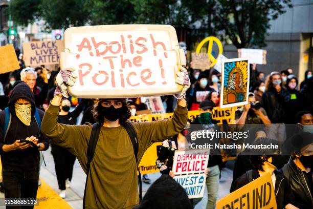 Protesters hold signs in support of defunding the police on July 25, 2020 in Oakland, California. Demonstrators in Oakland gathered to protest in...