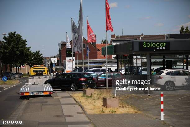 June 2023, North Rhine-Westphalia, Grevenbroich: Tow truck in front of a car dealership. Investigators took action Wednesday in an international...