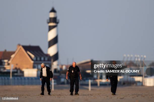 French National Police officers patrol on the beach to search for migrants attempting to cross the English Channel to reach Britain, in Gravelines,...