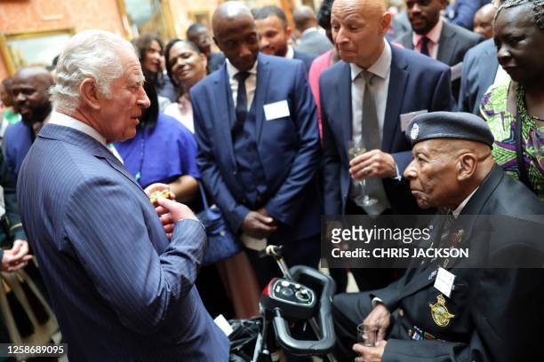 Britain's King Charles III speaks with guests during a reception to celebrate the Windrush Generation and mark the 75th anniversary of the arrival of...