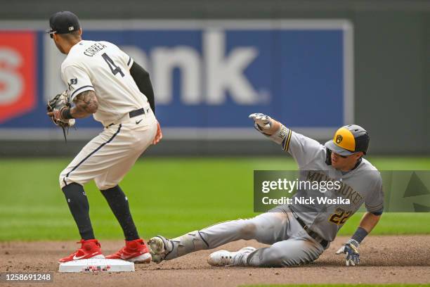 Christian Yelich of the Milwaukee Brewers slides safely into second base on a double as Carlos Correa of the Minnesota Twins awaits a throw at Target...