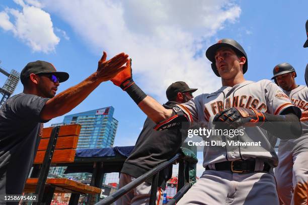 Mike Yastrzemski of the San Francisco Giants is congratulated after hitting a game-tying two-run home run against the St. Louis Cardinals in the...