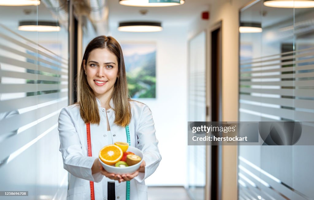 Female nutritionist doctor hands holding fruits