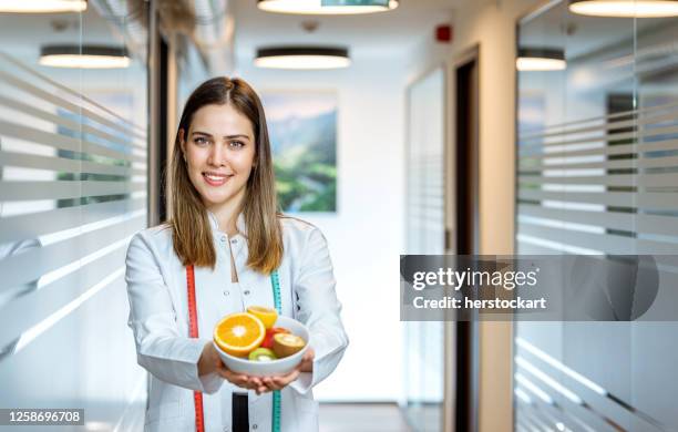 nutricionista feminina de mãos segurando frutas - nutritionist - fotografias e filmes do acervo