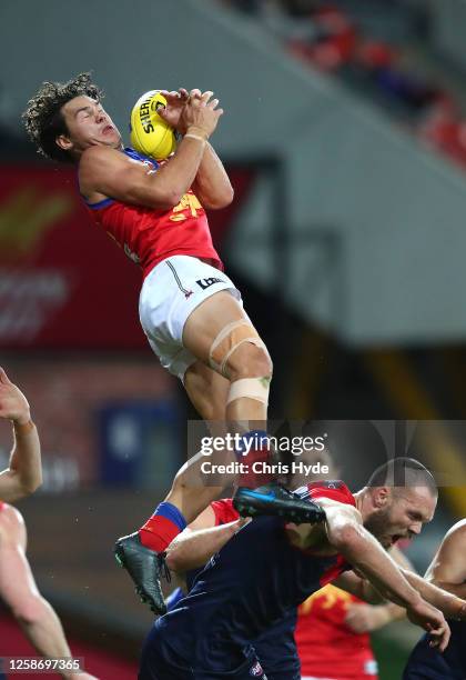 Cameron Rayner of the Lions flies for a mark over Max Gawn of the Demons during the round 8 AFL match between the Melbourne Demons and the Brisbane...