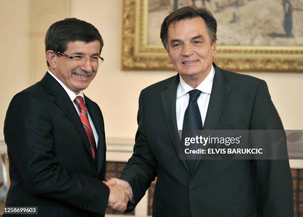 Turkish Foreign Affairs minister Ahmet Davutoglu shakes hands with member of Bosnia's tripartite Presidency, Haris Silajdzic in Sarajevo, on October...