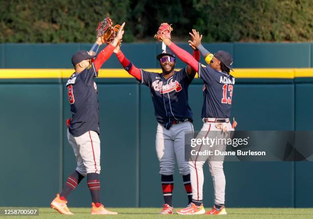 Left fielder Eddie Rosario of the Atlanta Braves celebrates with center fielder Michael Harris II and right fielder Ronald Acuna Jr. #13 after a 6-5...