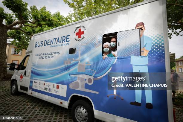 Luna Desnot and Maxime Bellocq , final-year dentistry students, stand at the window of the Red Cross dental bus parked in Simorre, southwestern...