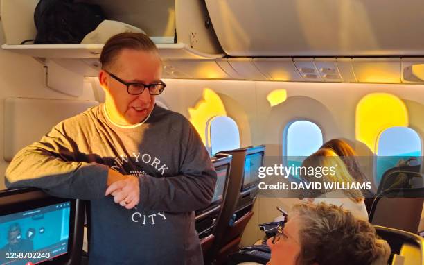 This picture taken on June 14, 2023 shows Australia's Qantas Group CEO Alan Joyce talking with passengers onboard an inaugural Qantas flight from...