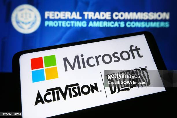 In this photo illustration, Microsoft and Activision Blizzard logos are seen on a smartphone and Federal Trade Commission logo on a pc screen.