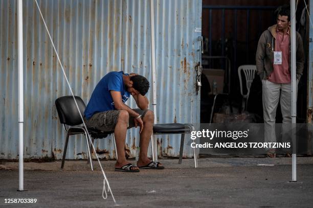 Survivors of a shipwreck stand at a warehouse at the port in Kalamata town, on June 15 after a boat carrying dozens of migrants sank in international...