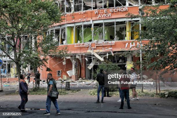 People stand outside an office building damaged by a recent missile attack of the Russian troops, Odesa, southern Ukraine. As reported, the Russian...