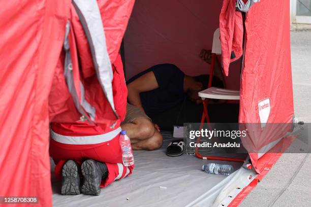 Rescued migrants receive aid inside a tent, following a shipwreck off shore in Kalamata, Greece on June 15, 2023
