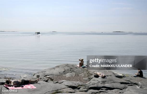 People sunbathe by the sea in Helsinki, Finland, on a hot summer day on June 15, 2023. / Finland OUT