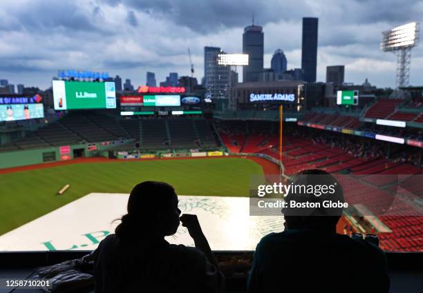 Boston Red Sox fans sit through a rain delay. The Red Sox beat the Colorado Rockies, 6-3.