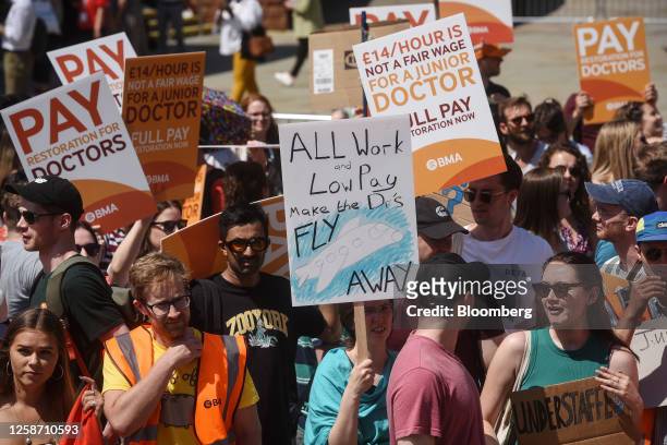 Junior doctors hold up placards at a protest outside the venue of the NHS ConfedExpo during the second day of strike action, at the Manchester...