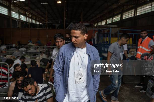 Rescued immigrants of a shipwreck after a boat carrying dozens of migrants sank in international waters of Ionian Sea, sit inside a warehouse in...