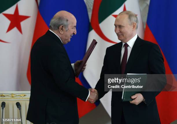 Russian President Vladimir Putin shakes hands with Algerian President Abdelmajid Tebboune during a signing ceremony at the Grand Kremlin Palace, June...
