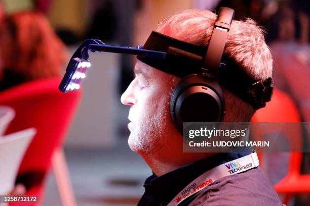 Visitor tries a light and music therapy device during the Vivatech technology startups and innovation fair in Paris on June 15, 2023.