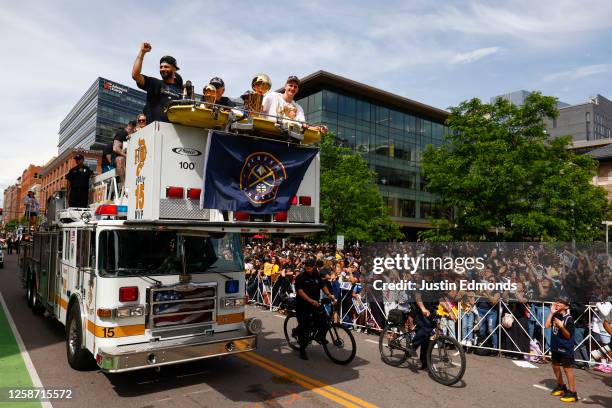 Jamal Murray and Nikola Jokic wave to fans with the Larry O'Brien Championship Trophy during the Denver Nuggets victory parade and rally after...