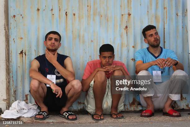 Rescued migrants wait outside a depot, following a shipwreck off shore in Kalamata, Greece on June 15, 2023